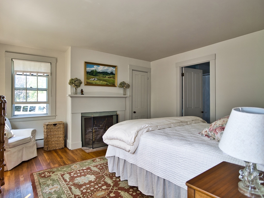 56 Maple Avenue Little Compton, RI 02837 - Photo 10 of 33 a bedroom with a bed and a fireplace