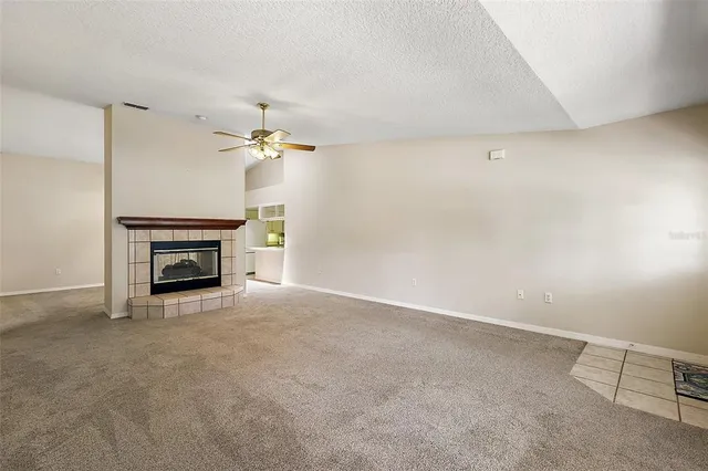 a view of a livingroom with a fireplace and a chandelier fan