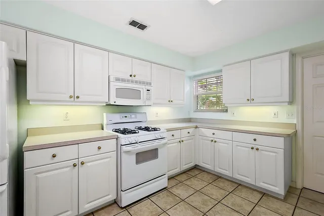 a kitchen with white cabinets appliances and a sink