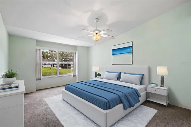 a bedroom with a large bed and a chandelier fan
