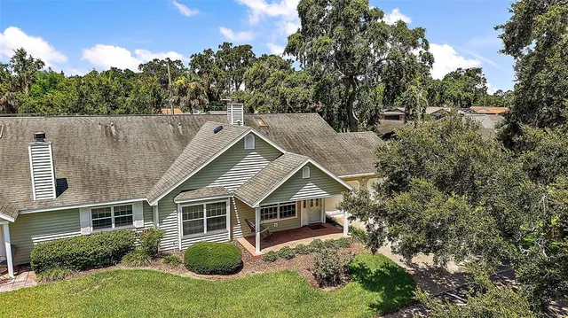 aerial view of house with yard and trees in the background