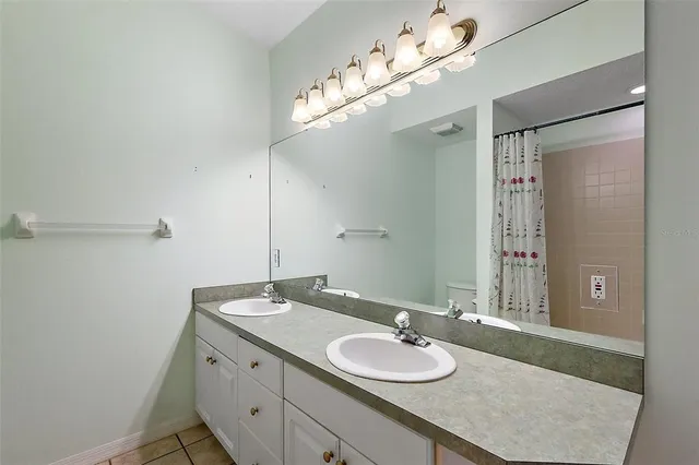 a bathroom with a granite countertop sink a large mirror and a shower