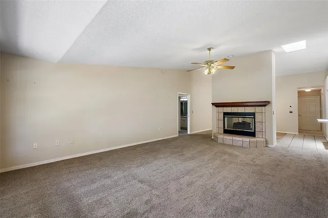 an empty room with a fireplace and fan
