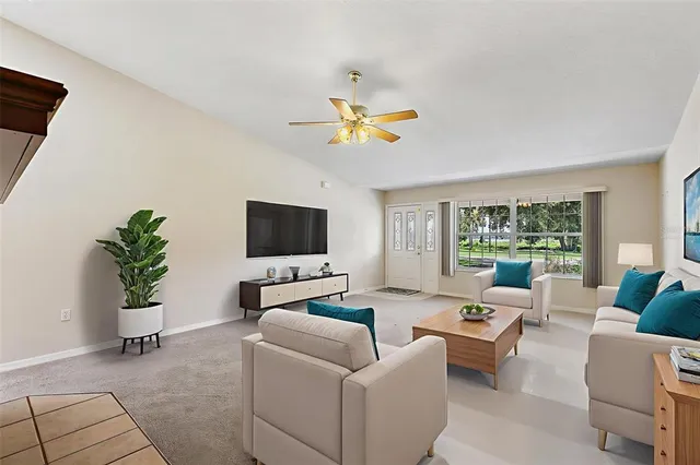 a living room with furniture a flat screen tv and a large window