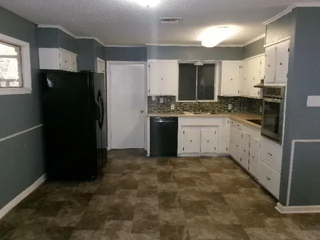 a kitchen with granite countertop a refrigerator and a sink