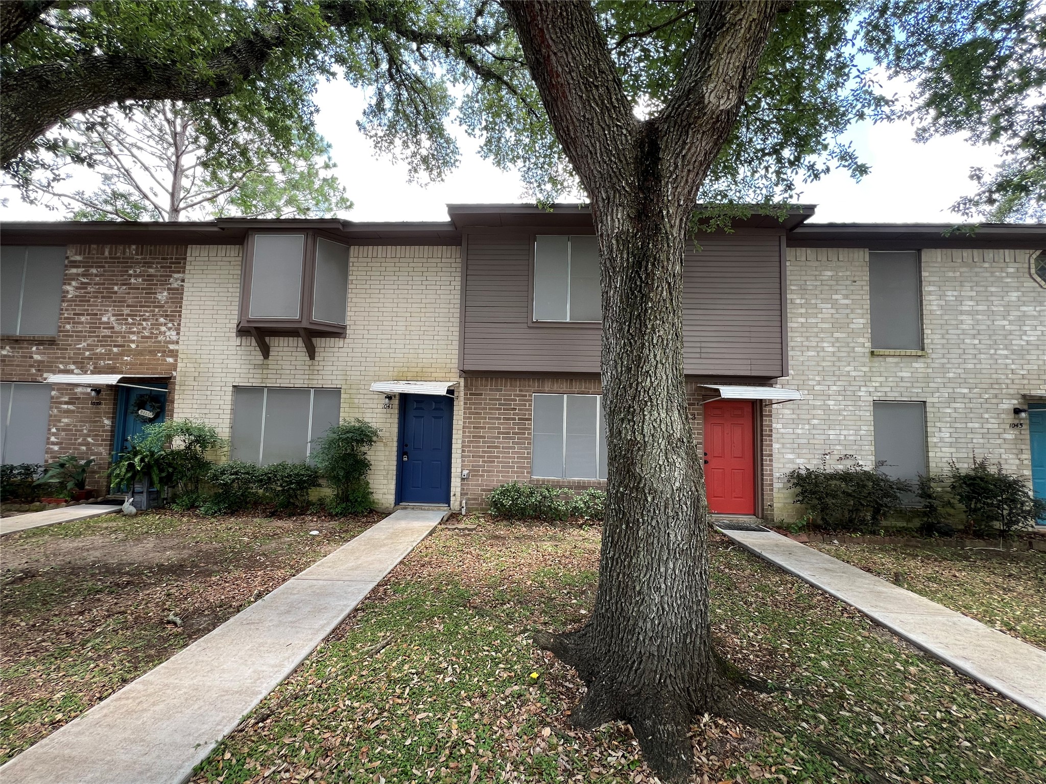 1039-1045 North Chenango Street Angleton, TX 77515 - Photo 2 of 17 a front view of a house with a yard