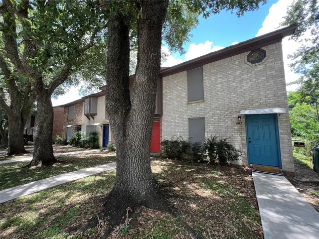 a front view of a house with yard tree and outdoor seating