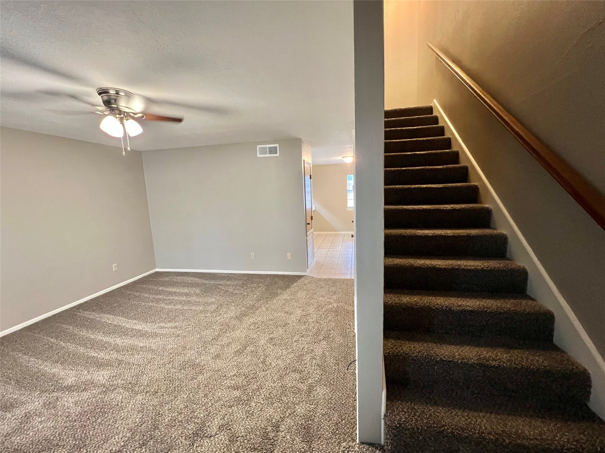 1039-1045 North Chenango Street Angleton, TX 77515 - Photo 6 of 17 a view of an empty room with stairs and a ceiling fan