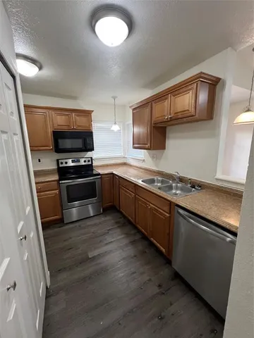 a kitchen with stainless steel appliances granite countertop a stove a sink and a microwave