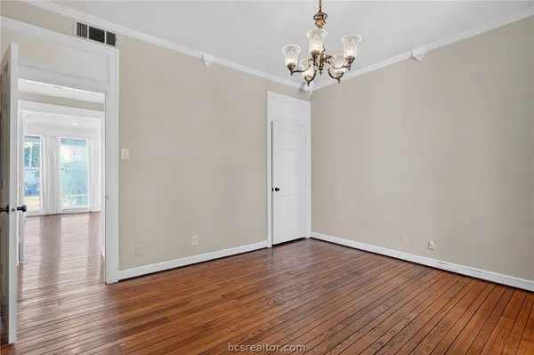 a view of a big room with wooden floor and a kitchen