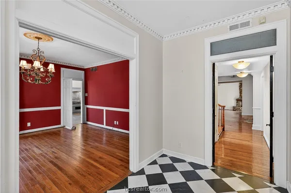 a view of a hallway with wooden floor and a cabinet