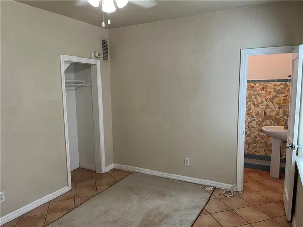 an empty room and chandelier fan