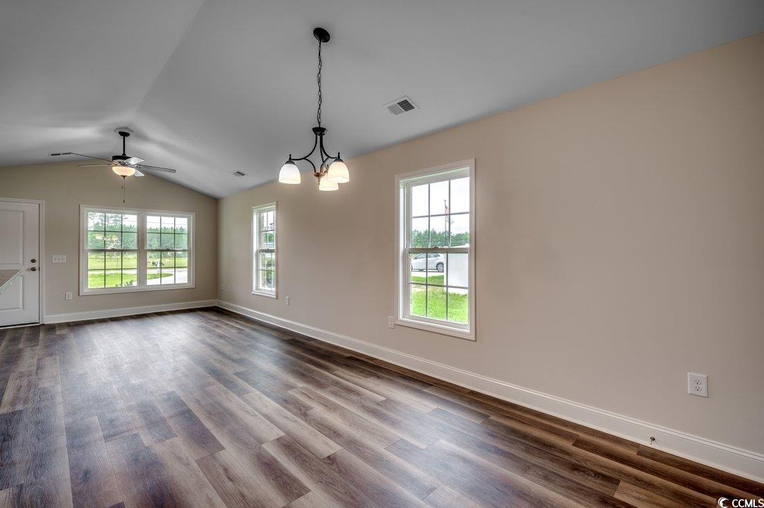 4911 Joyner Swamp Road Galivants Ferry, SC 29544 - Photo 7 of 28 Empty room with wood-type flooring, lofted ceiling, and ceiling fan with notable chandelier