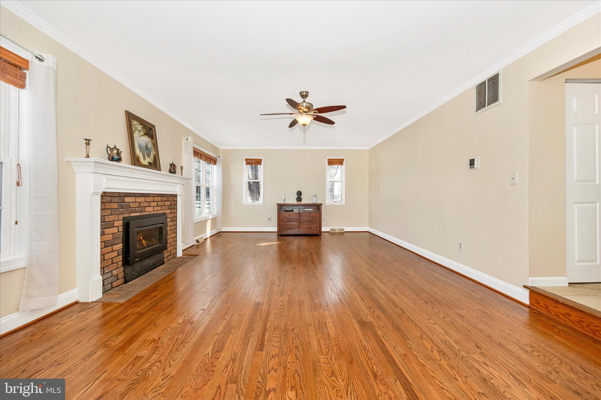3340 Florence Road Woodbine, MD 21797 - Photo 5 of 61 a view of a livingroom with a fireplace a ceiling fan and wooden floor