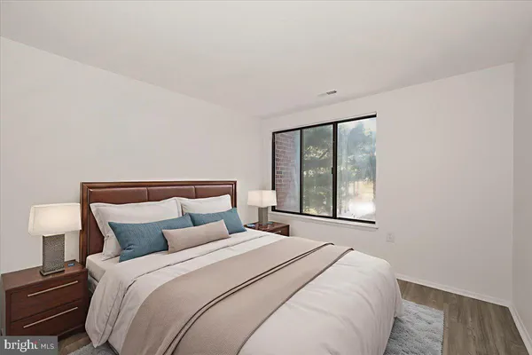 a bedroom with a bed and a large window