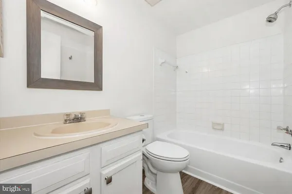 a bathroom with a toilet a sink a mirror and a bathtub