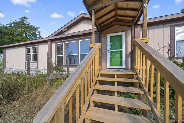a view of a house with wooden stairs and a large window