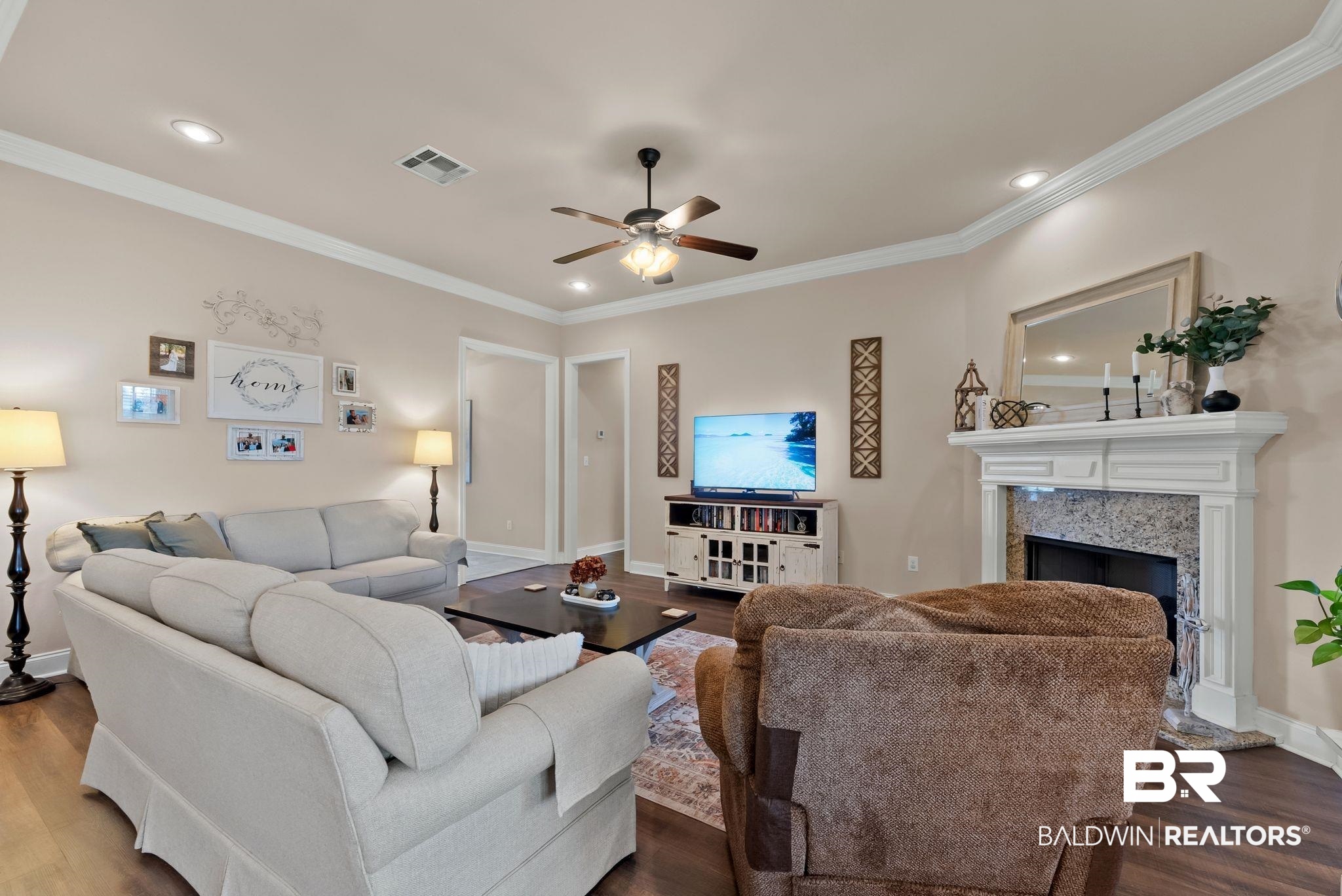 7015 Rocky Rd Loop Gulf Shores, AL 36542 - Photo 6 of 41 Living room with wood finished floors, a ceiling fan, crown molding, a high end fireplace, and recessed lighting