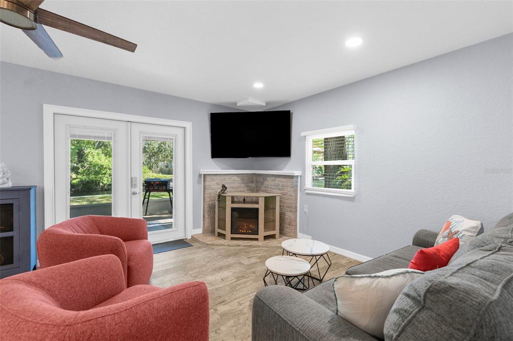 5421 Gay Street Weeki Wachee, FL 34607 - Photo 13 of 55 a living room with furniture a fireplace and a flat screen tv