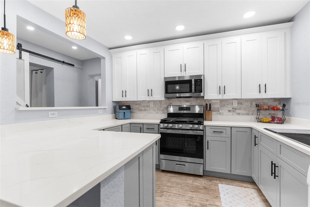 5421 Gay Street Weeki Wachee, FL 34607 - Photo 16 of 55 a kitchen with stainless steel appliances granite countertop a sink a stove a microwave a refrigerator a counter top space and cabinets