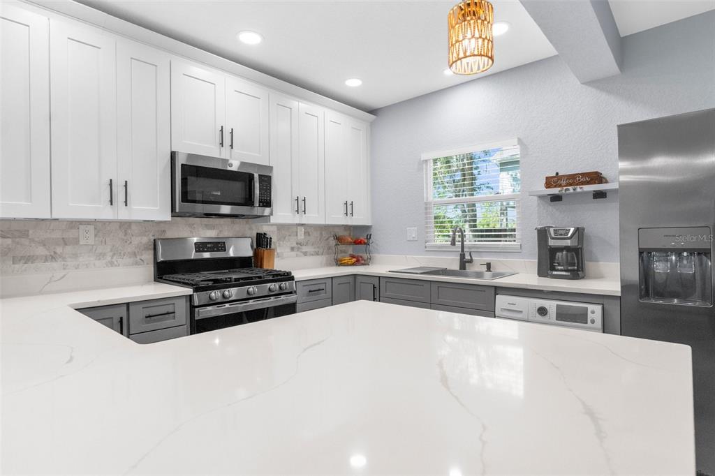 5421 Gay Street Weeki Wachee, FL 34607 - Photo 22 of 55 a kitchen with stainless steel appliances a stove sink microwave and cabinets