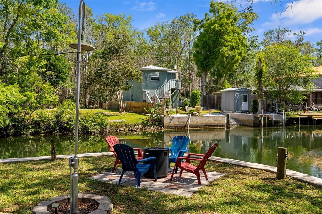 5421 Gay Street Weeki Wachee, FL 34607 - Photo 7 of 55 a view of a lake with table and chairs potted plants and large trees