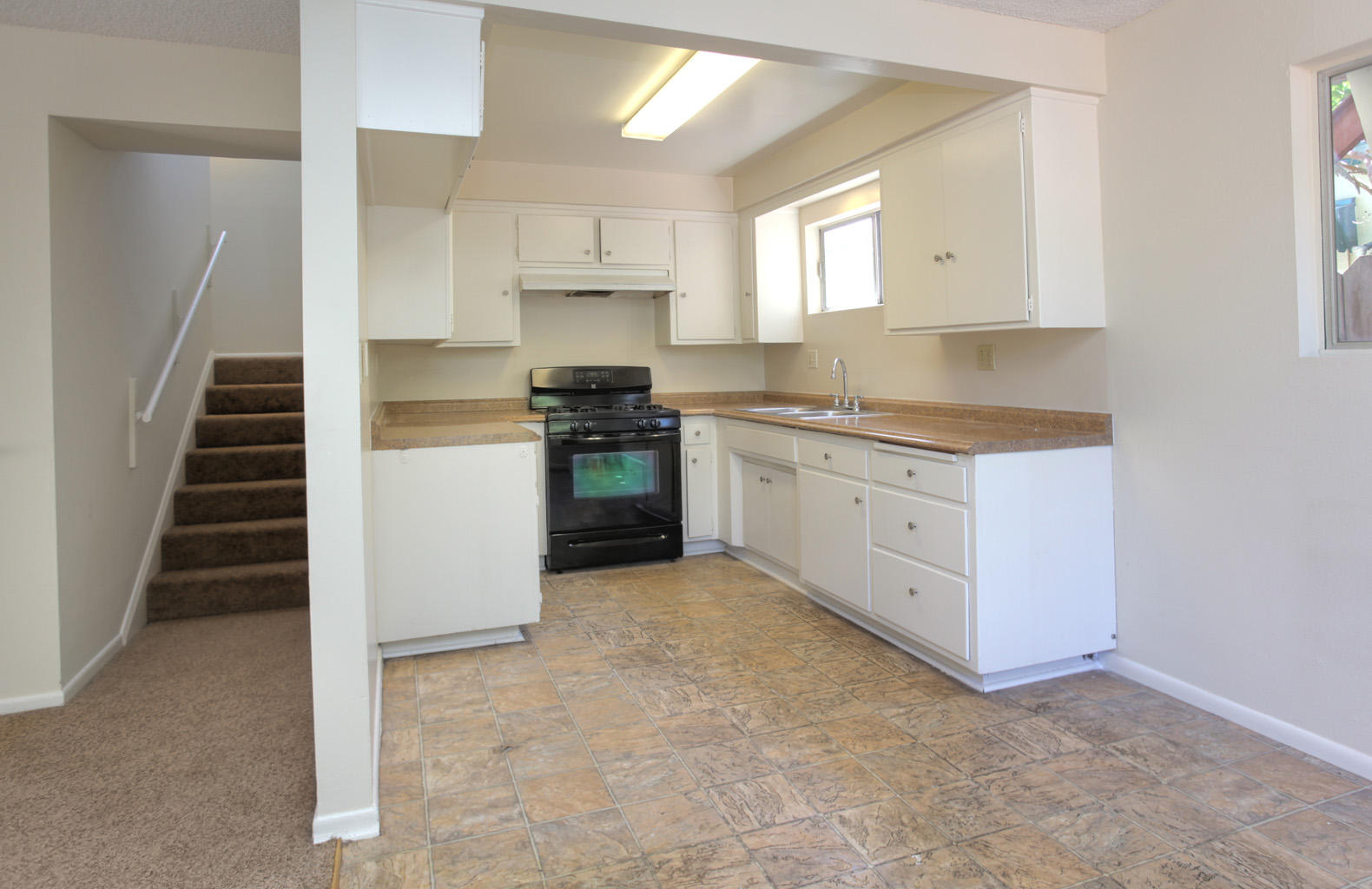 460 Fellowship Road Santa Barbara, CA 93109 - Photo 3 of 21 a kitchen with granite countertop a sink a stove and cabinets