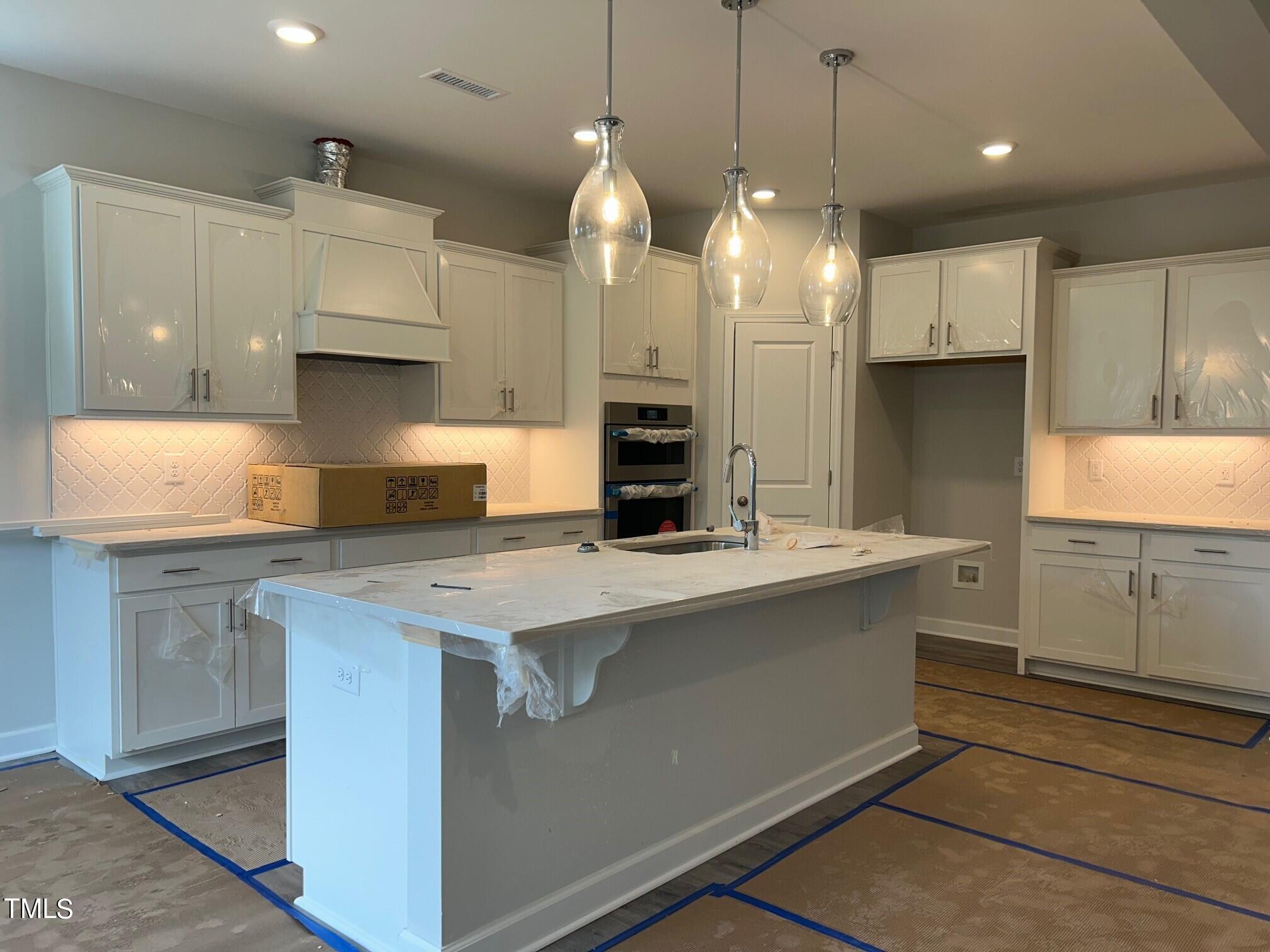 62 Golden Leaf Farms Road Angier, NC 27501 - Photo 4 of 31 a kitchen with kitchen island a stove a sink a center island and a window