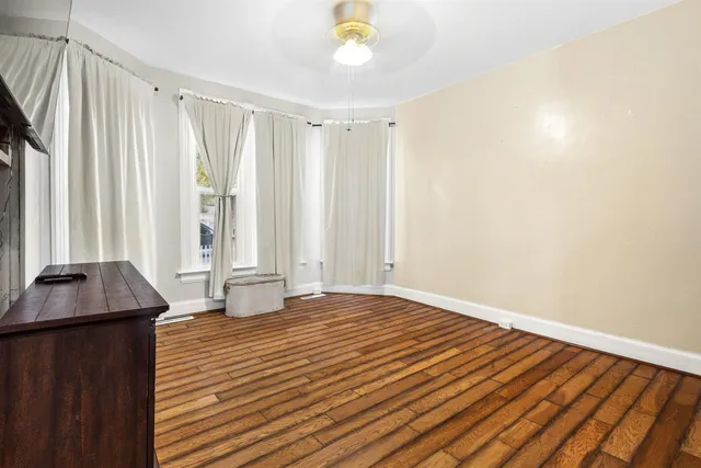a view of a room with wooden floor and a window