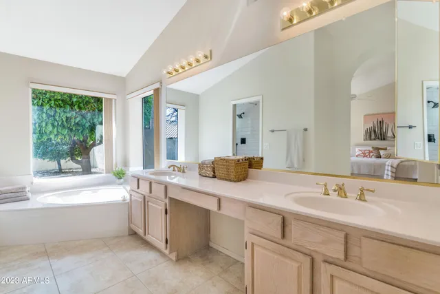 a bathroom with a sink double vanity mirror and bathtub