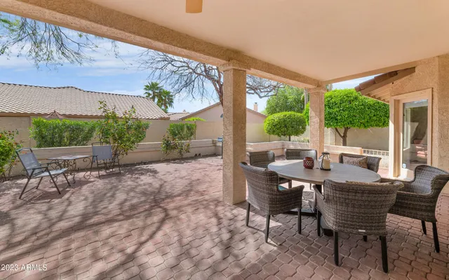 a view of a patio with a dining table and chairs with wooden floor