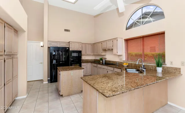 a kitchen with stainless steel appliances granite countertop a sink and a refrigerator