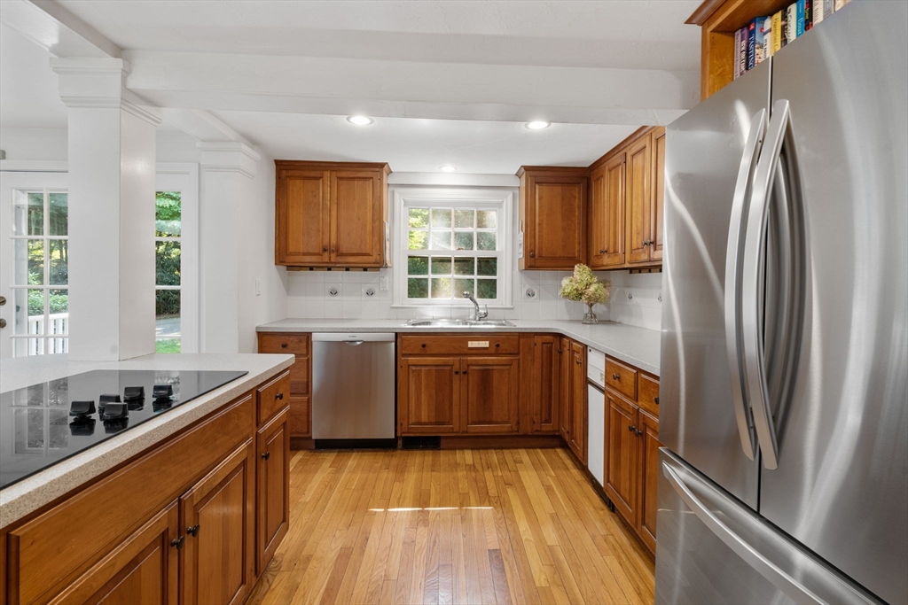 18 Normandie Road Dover, MA 02030 - Photo 4 of 39 a kitchen with stainless steel appliances granite countertop a refrigerator a sink dishwasher a stove and white countertops with wooden floor