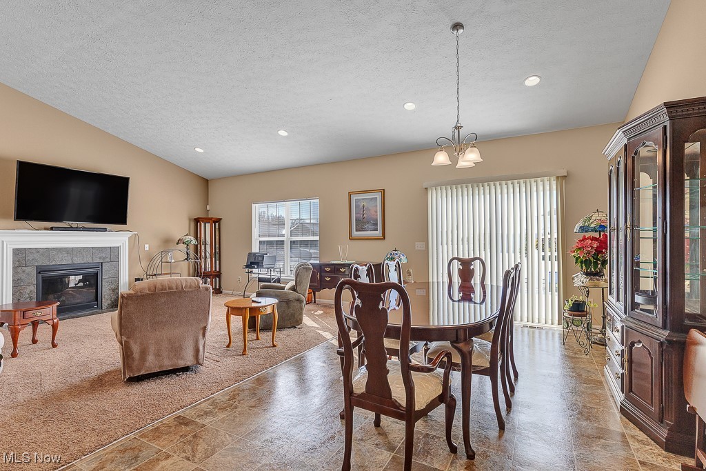 37289 Sandy Ridge Drive North Ridgeville, OH 44039 - Photo 7 of 21 Dining room with a fireplace, an inviting chandelier, and a textured ceiling