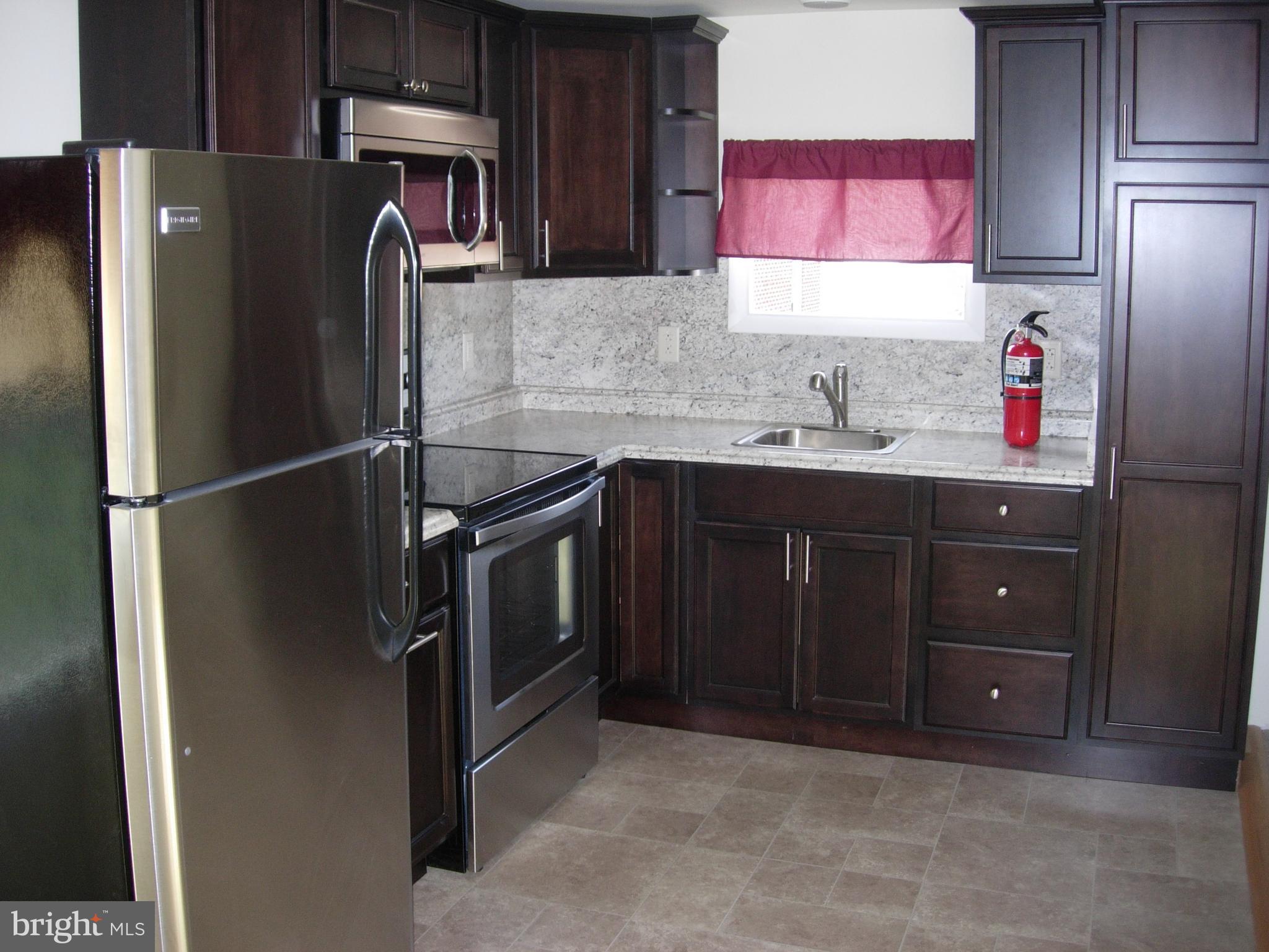 108 South Kenhorst Boulevard Reading, PA 19607 - Photo 4 of 30 a kitchen with stainless steel appliances granite countertop a refrigerator and a sink