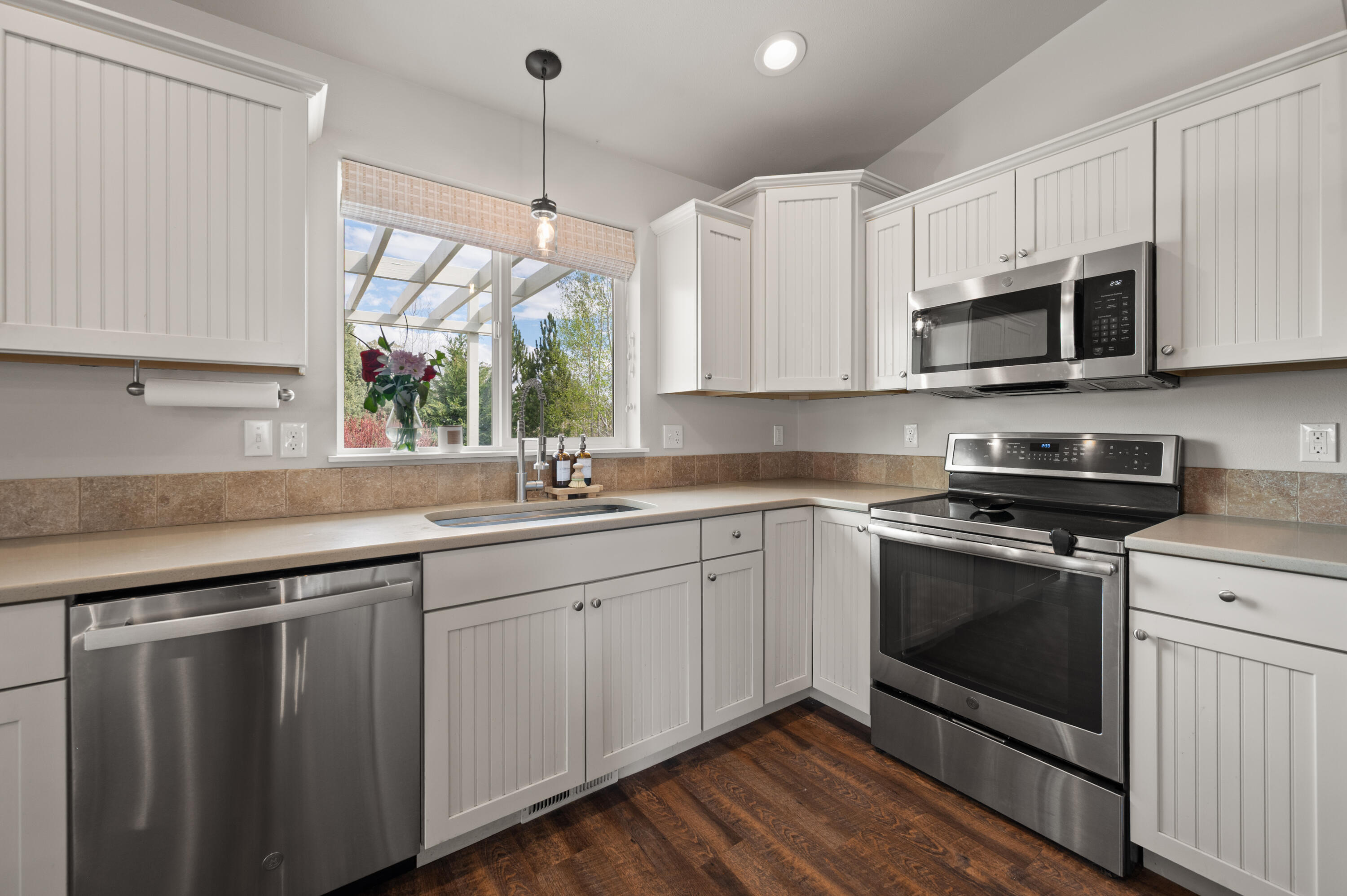 16625 Southwest Dove Road Terrebonne, OR 97760 - Photo 21 of 50 a kitchen with stainless steel appliances granite countertop a sink a stove a microwave and wooden floors