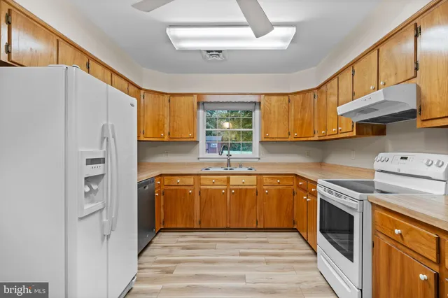 a kitchen with stainless steel appliances granite countertop a stove a sink and a refrigerator