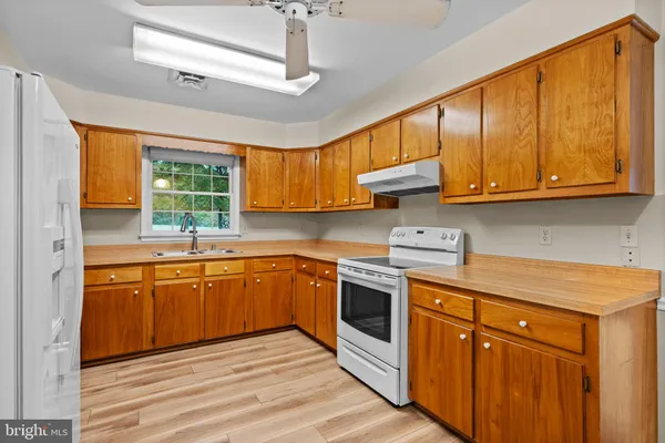 a kitchen with stainless steel appliances granite countertop wooden cabinets a sink and a stove