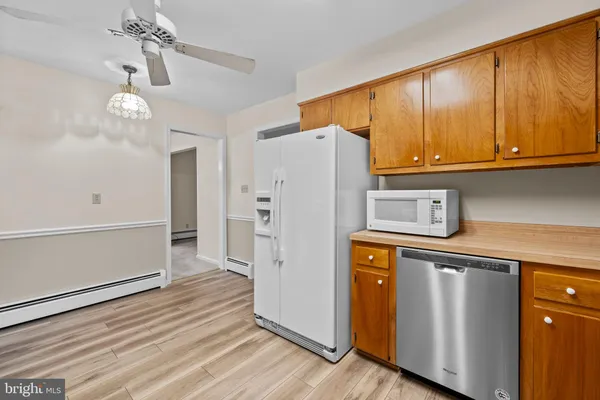 a kitchen with stainless steel appliances granite countertop a refrigerator a oven and a microwave with wooden floor