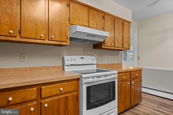 a kitchen with wooden cabinets and a stove top oven