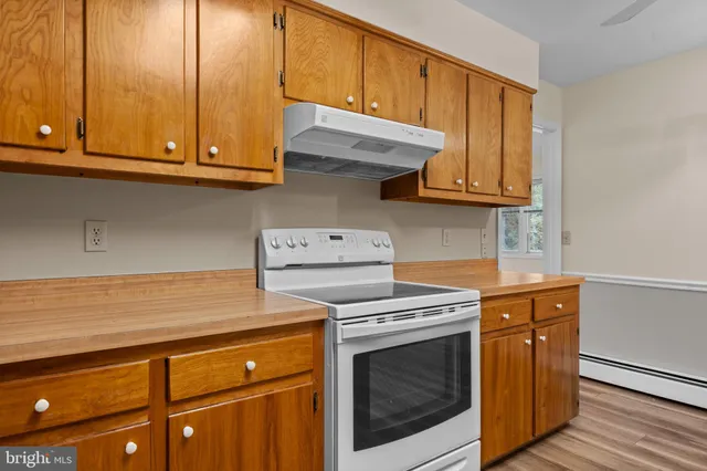 a kitchen with wooden cabinets and a stove top oven