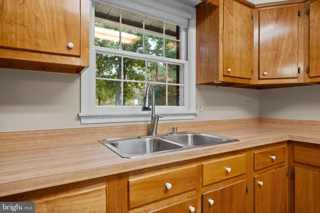 a kitchen with granite countertop sink and cabinets