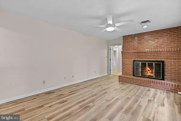 a view of empty room with wooden floor and fireplace