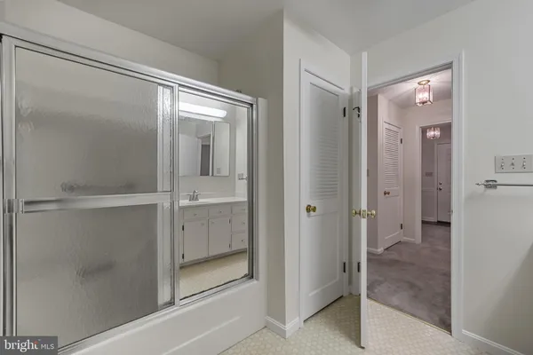 a bathroom with a glass shower door and a glass door
