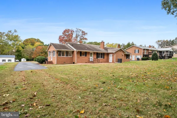 a view of a house with a big yard and large tree