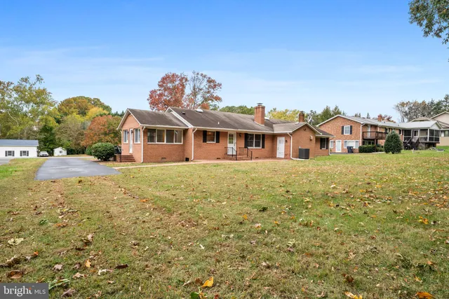 a view of a house with a big yard and large tree