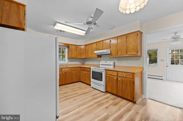 a kitchen with stainless steel appliances granite countertop a sink cabinets and wooden floor