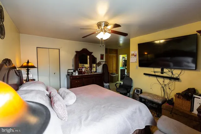 a bedroom with a bed and a flat tv screen on dresser