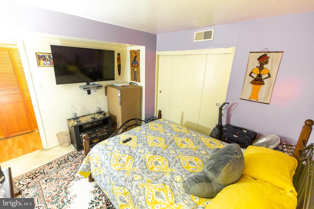 11200 Cherry Hill Road, Unit 54 Beltsville, MD 20705 - Photo 8 of 18 a bedroom with a bed and flat screen tv