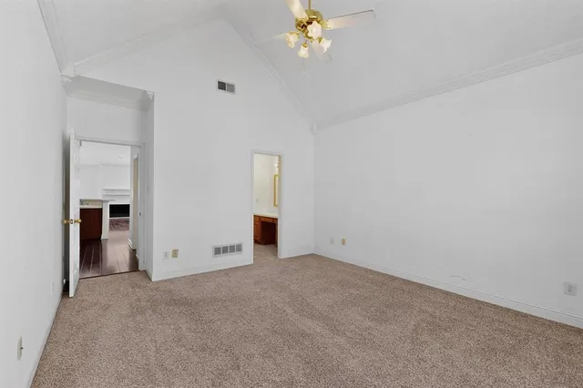 an empty room with chandelier fan